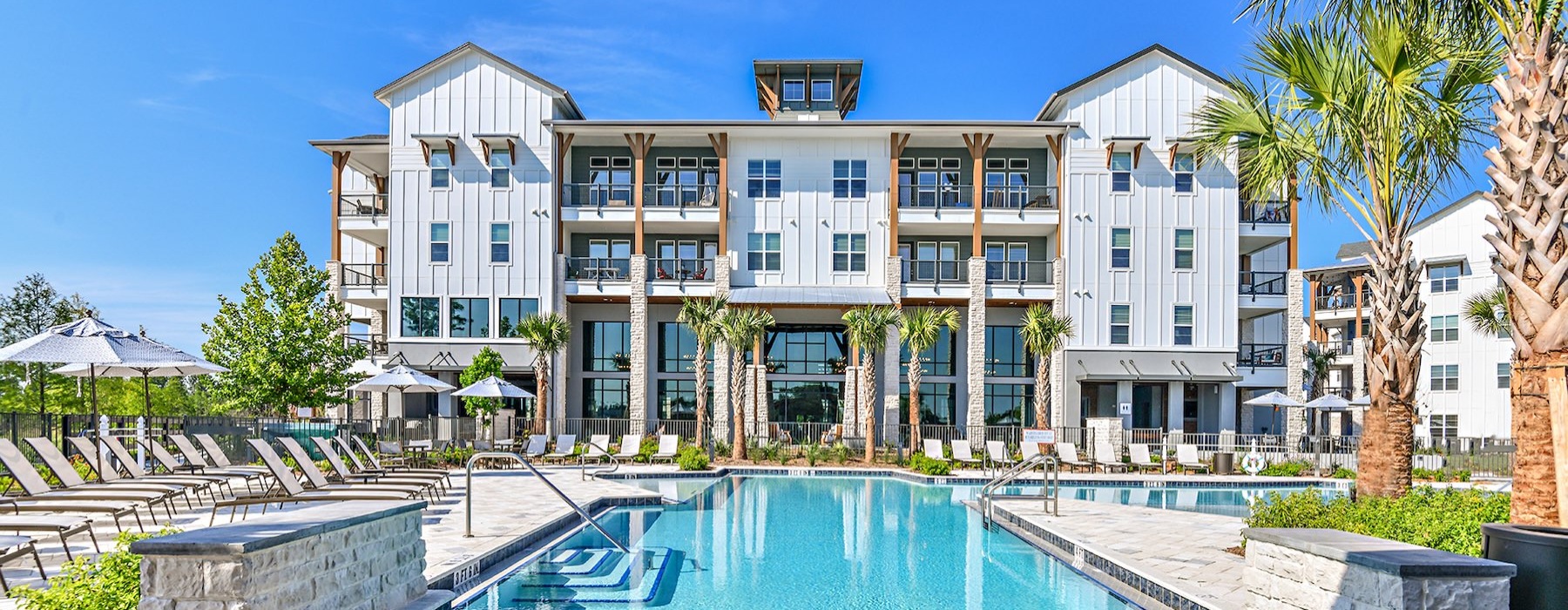 a building with a pool and palm trees